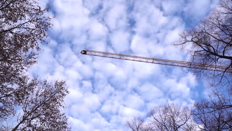 Slow-motion-view-of-high-construction-crane-panning-across-beautiful-sky