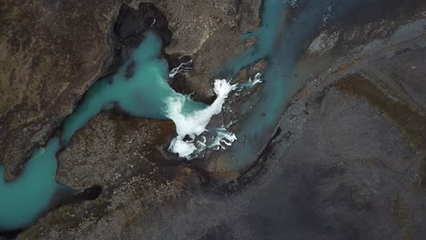 Atemberaubende-Natur-Islands,-Blick-Von-Oben-Auf-Den-Gletscherwasserfall-Und-Die-Schlucht-Zwischen-Vulkanhügeln,-Vogelperspektive