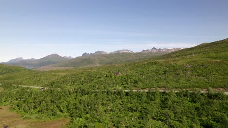 Paisaje-Droneshot-Volando-Sobre-El-Bosque-En-El-Norte-De-Noruega-Con-Montañas-En-El-Fondo