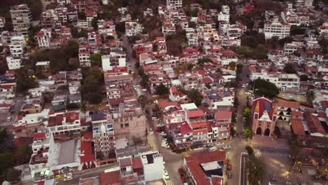Hyperlapse-helix-spin-aerial-drone-view-reveal-of-popular-downtown-el-centro-center-and-Church-of-Our-Lady-of-Guadalupe-of-puerto-vallarta-mexico-with-mountains-in-back-during-golden-hour