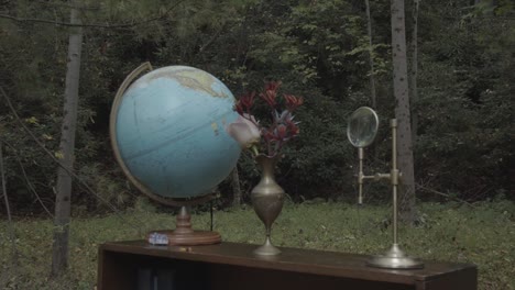 Globus-Und-Antiquitäten-Auf-Dem-Tisch-Im-Garten