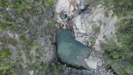 Ascending-overhead-cenital-shot-of-water-stream-pond-in-a-rocky-mountain-area-at-Geres-National-Park-in-Portugal