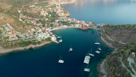 Aerial-view-Natural-bay-with-sailing-boats-anchored-emerald-sea,-Assos-Village,-Kefalonia-Island