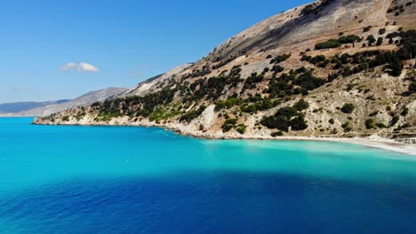 Ruhiger-Blauer-Ozean-Und-üppige-Klippen-Am-Strand-Von-Agia-Kiriaki-In-Griechenland---Drohnenaufnahme-Aus-Der-Luft