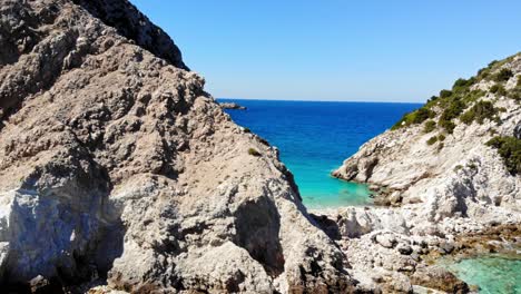 Rocky-Cliffs-and-Turquoise-Ocean-at-Agia-Eleni-Beach-in-Greece---aerial-drone-shot