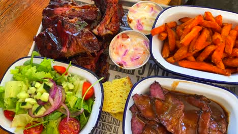 Beef-brisket-with-salad,-pork-ribs-with-sweet-potato-fries,-cornbread-and-coleslaw,-traditional-american-food,-4K-shot