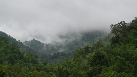 Fog-captured-moving-fast-in-a-time-lapse-over-the-mountains-in-Sai-Yok,-Kanchanaburi,-Thailand,-during-a-rainy-afternoon