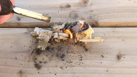 Closeup-point-of-view-shot-of-setting-paper-on-fire-on-wooden-plank