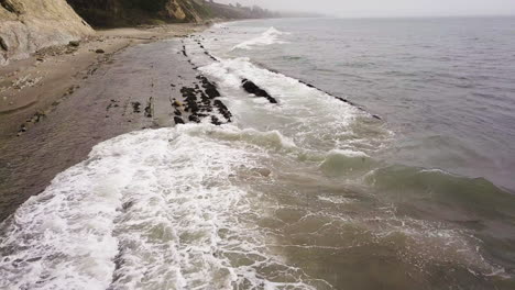 Wild-shore-waves-hittting-the-rocks-of-California-Coast-aerial