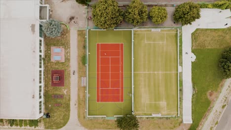 Aerial-descending-top-down-view-of-a-multi-sport-field,-soccer-field-and-a-skate-park