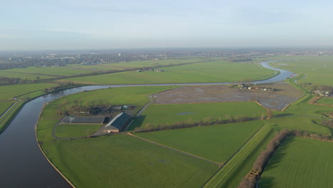 Aerial-of-a-beautiful-farm-in-rural-meadows-near-a-river-in-Dutch-countryside