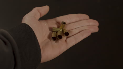 Hand-opening-and-revealing-9mm-bullet-shell-cases