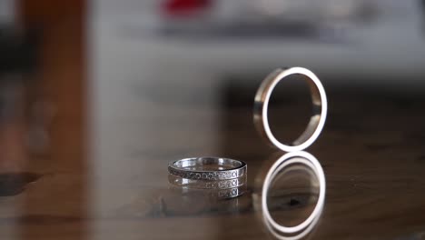Close-up-of-a-wife's-wedding-ring-on-the-table-as-the-husband's-rolls-by