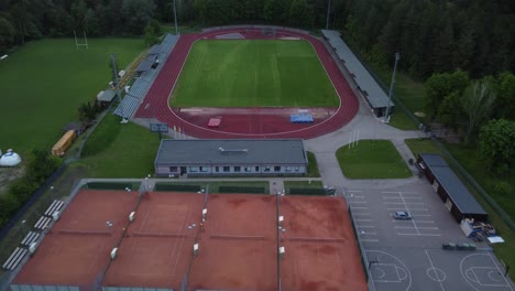 Sports-stadium-complex-with-different-courts,-aerial-drone-zooming-in-view