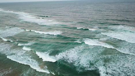 drone-shot-slowly-dropping-towards-breaking-waves