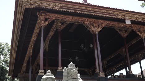 This-is-a-roof-and-inside-Ubud-palace,-filming-handheld,-the-camera-tilted-down