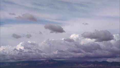 Cloud-timelapse-over-mountain-range-in-California-Mojave-Desert,-AERIAL