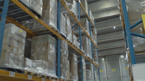 Slow-tilt-up-of-high-rack-in-busy-industrial-warehouse