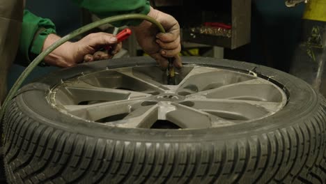 Close-up-of-Caucasian-hands-of-a-mechanic-inflating-a-car-wheel