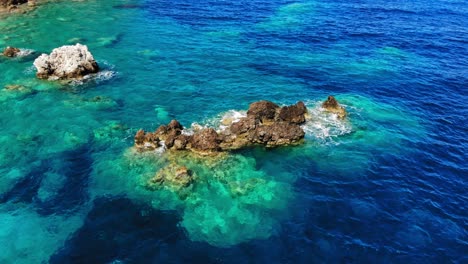 Beautiful-Seascape-With-Waves-Splashing-On-Rocks-In-Agia-Eleni-Beach,-Greece---aerial-orbit