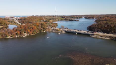 High-aerial-view-of-team-of-rowers-exiting-from-underneath-road-bridge