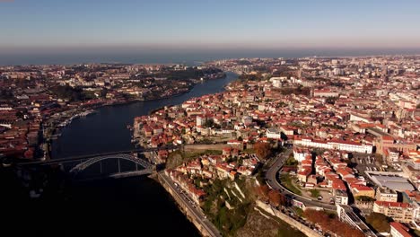Vista-Aérea-De-Oporto,-Capital-De-Portugal,-Imágenes-épicas-De-Drones-Del-Paisaje-Urbano-Con-Un-Puente-Que-Cruza-El-Río-Douro