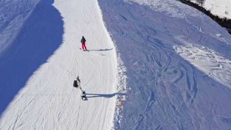 Luftaufnahmen-Von-Skifahrern-Und-Snowboardern,-Die-Den-Verschneiten-Hang-Hinuntergehen