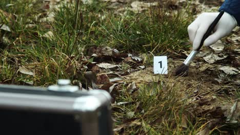 Crime-scene-evidence,-bullet-in-dust-and-case-in-foreground,-closeup-view