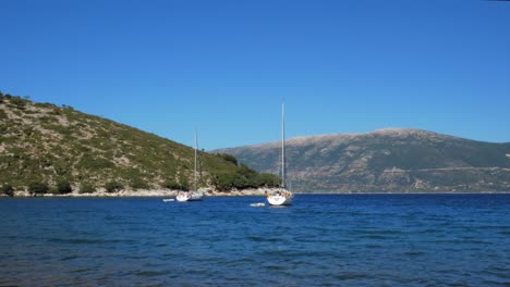 Segelboote,-Die-Auf-Ruhigem-Blauem-Meer-Nahe-Agia-Eleni-Beach-In-Griechenland-Schwimmen