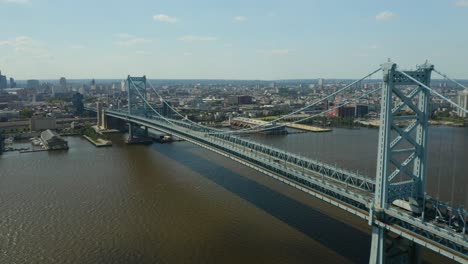Aerial---Tractor-Trailer-crosses-over-bridge-to-enter-urban-city