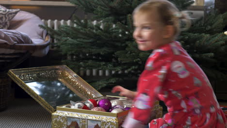 A-young-child-opens-a-golden-box-with-ornaments-inside-and-smiles