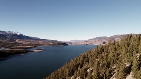 Flying-Through-Coniferous-Lakeside-Pine-Tree-Mountain-Hillside-Slope-Revealing-Lake-In-Sapphire-Point,-Colorado