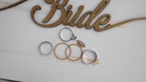 Wedding-rings-placed-in-a-rustic-wooden-Bride-sign