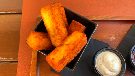 Deep-fried-polenta-chips-sticks-and-cheese-sticks,-traditional-tapas-in-a-restaurant,-4K-shot