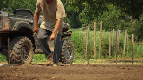 Agricultor-Estableciendo-Apuestas-Que-Servirán-Como-Guía-Para-Arar-Un-Campo-De-Cultivo,-Concepto-De-Trabajador-Duro