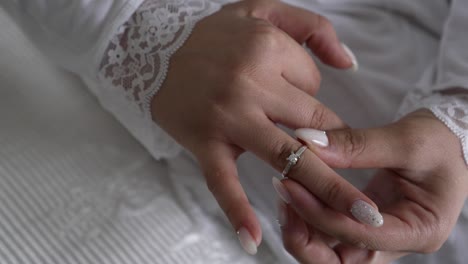 Eine-Braut-In-Ihrem-Hochzeitskleid-Legt-Ihren-Verlobungsring-An-Ihren-Finger
