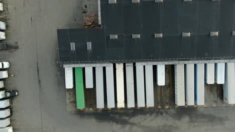 Top-down-aerial-of-cargo-trailers-lined-up-a-distribution-center-in-United-States,-cargo,-shipping,-transportation,-logistics-concept