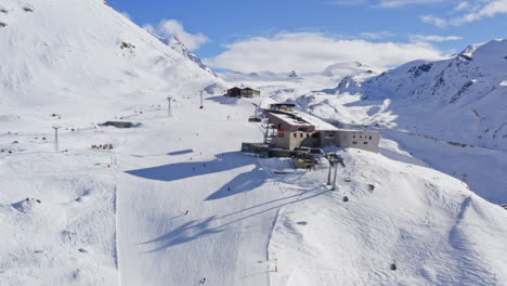 Luftdrohnenübersicht-über-Skigebiet-Und-Skifahrer,-Die-In-Den-Alpen-Bergab-Fahren