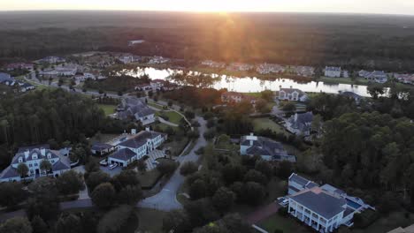 Luftaufnahme-Der-Nachbarschaft-Von-North-Florida-Mit-Teich,-Der-Bei-Sonnenuntergang-An-Dichten,-Unbebauten-Wald-Grenzt