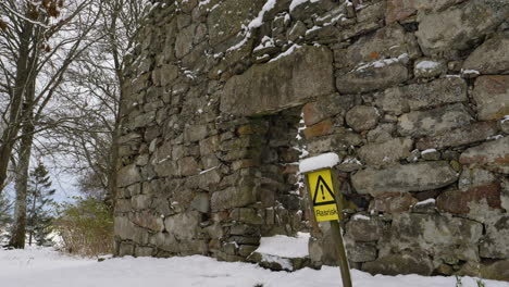 Danger-falling-rocks-sign-in-church-ruin-in-winter-day