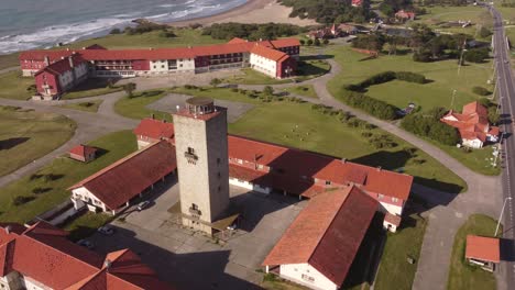 Aerial-orbit-shot-of-old-hotel-resort-with-ocean-view-and-sandy-beach-during-sunny-day--Chapadmalal,Argentina