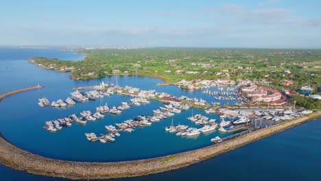 Aerial-flyover-luxury-marina-with-parking-yachts-and-boats-in-La-Romana-during-sunset---Dominican-Republic-Island