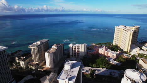 Slow-pan-right-to-left-of-resorts-on-Waikiki-beach-on-Oahu-Hawaii-with-blue-ocean-water---Aerial-view