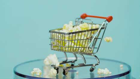 Einkaufswagen-Gefüllt-Mit-Popcorn-In-Zeitlupe-Mit-Babyblauem-Hintergrund