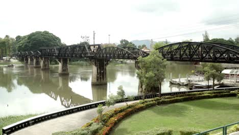 A-static-shot-of-the-historic-Bridge-Over-the-River-Kwai,-a-World-War-2-landmark-and-a-popular-tourist-attraction-in-Kanchanaburi,-Thailand