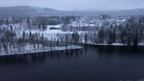 Forward-aerial-above-lake,-snowy-landscape,-Osterdalalven,-Sweden