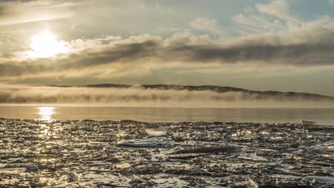 Frozen-lake-with-morning-mist-and-ice-foreground-rolling-clouds