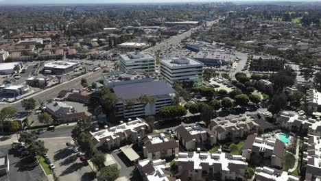 Aerial,-tracking,-drone-shot-around-a-buildings-rooftop,-covered-with-Solar-panels,-on-a-sunny-day,-at-Long-Beach,-in-Los-Angeles,-California,-USA