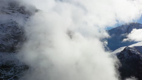 Rotating-drone-footage-of-the-cloudy-Swiss-Alps-in-Switzerland-with-snow-on-the-peaks