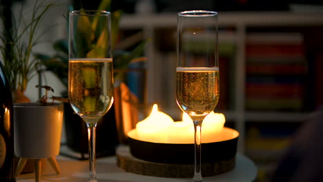 Paar-Flötengläser-Gefüllt-Mit-Sprudelndem-Champagner-Auf-Dem-Tisch-Mit-Kerzenlicht